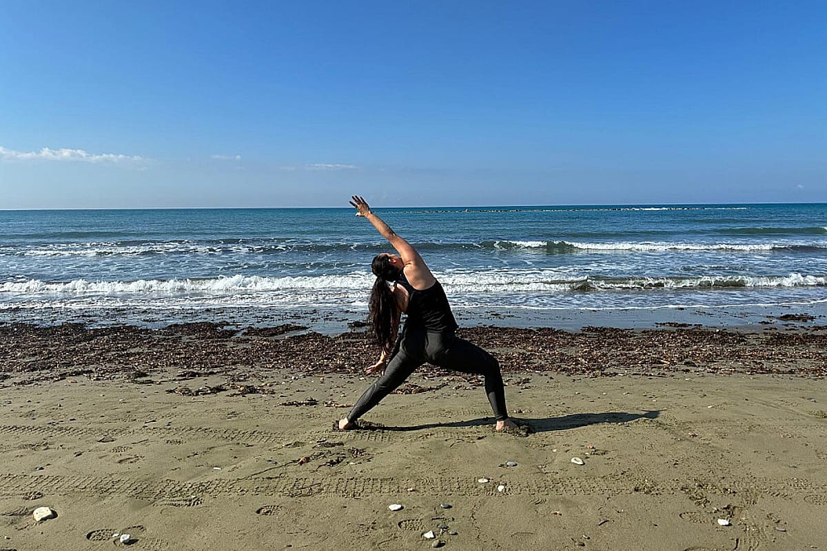 Frau bei einer sanften Yogaübung am Meer auf Zypern